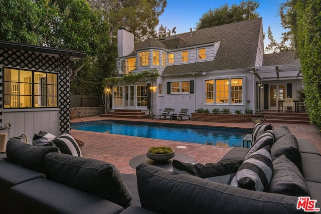 back of property featuring an outdoor living space, a patio area, and french doors