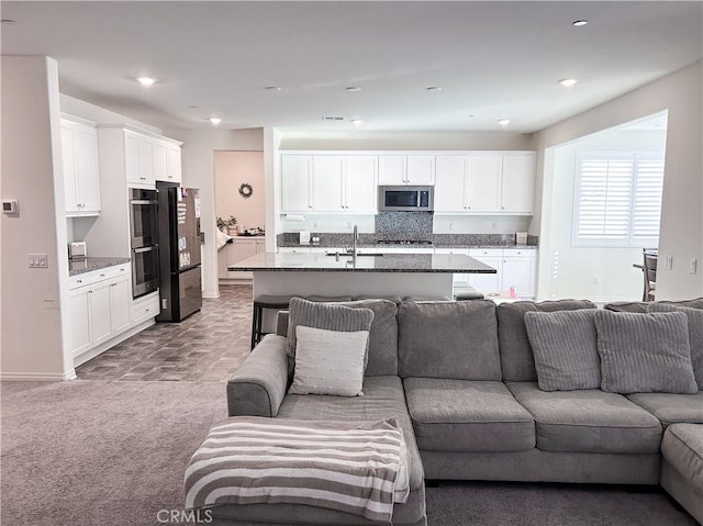 carpeted living room featuring sink