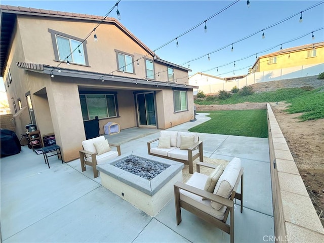 rear view of house with an outdoor living space with a fire pit, a patio area, and a lawn