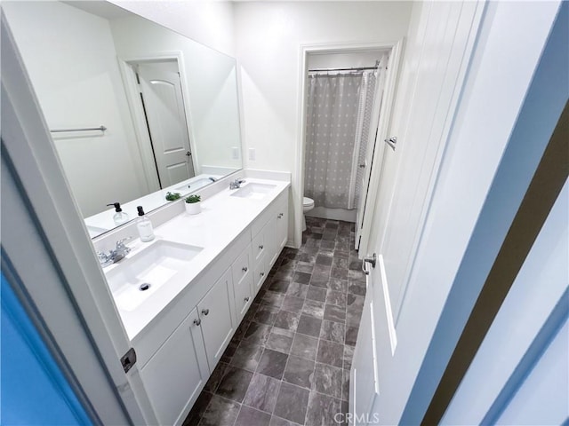 bathroom with vanity, toilet, and curtained shower