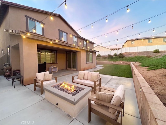 back house at dusk featuring an outdoor living space with a fire pit and a patio area