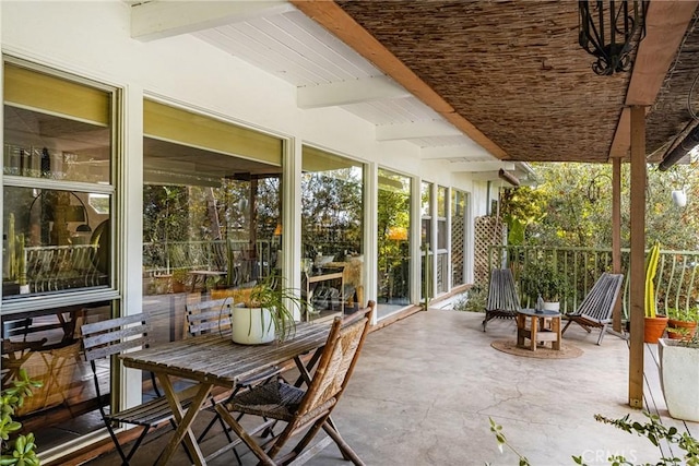 sunroom / solarium featuring beam ceiling