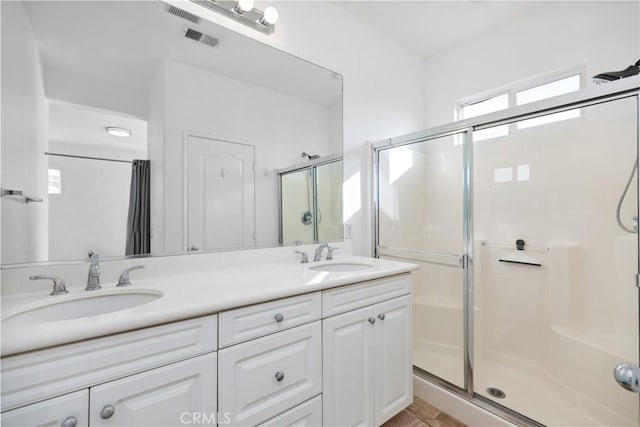 bathroom with vanity and a shower with door