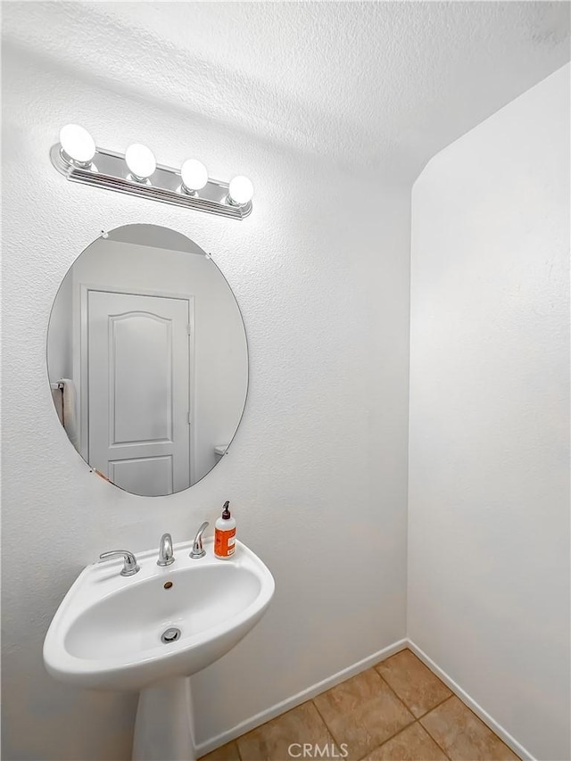 bathroom featuring sink, tile patterned floors, and a textured ceiling