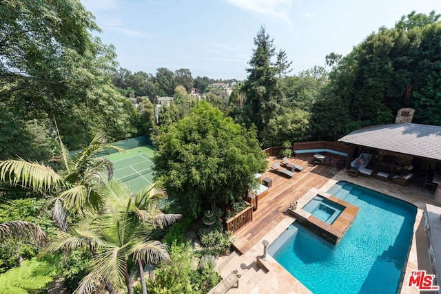 view of swimming pool featuring an in ground hot tub, exterior bar, and a wooden deck