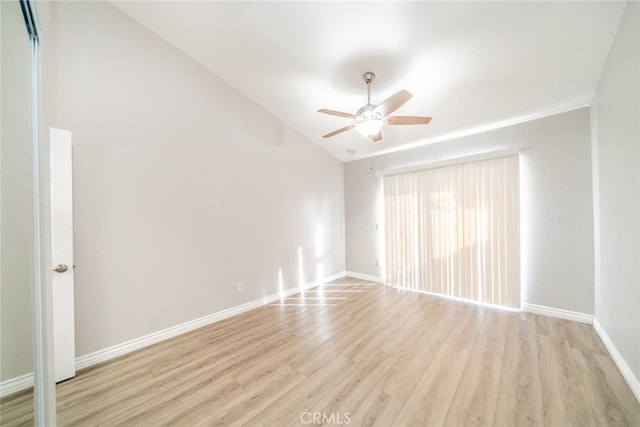 empty room with vaulted ceiling, ceiling fan, and light hardwood / wood-style floors