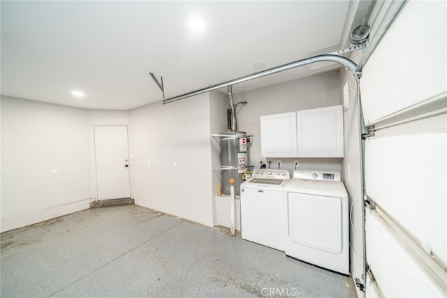 garage with strapped water heater and washer and dryer