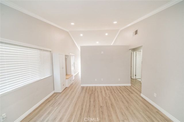 spare room with crown molding, lofted ceiling, and light wood-type flooring