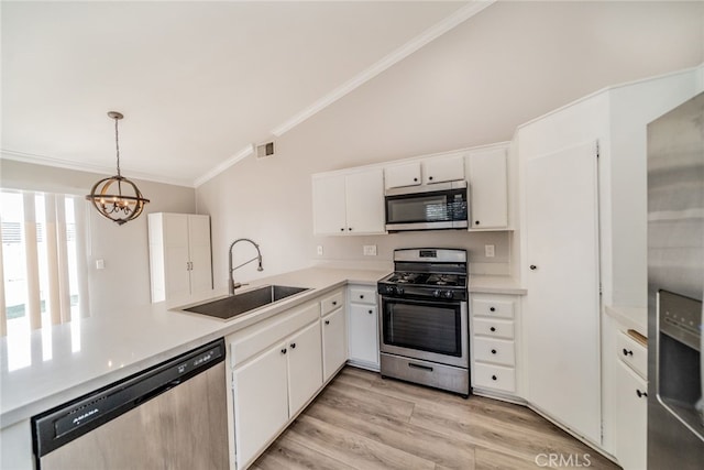 kitchen with sink, white cabinetry, a chandelier, pendant lighting, and stainless steel appliances