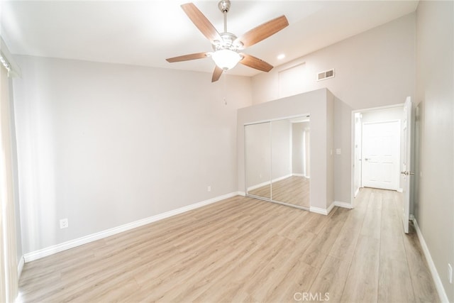 unfurnished bedroom with light hardwood / wood-style flooring, a closet, and ceiling fan