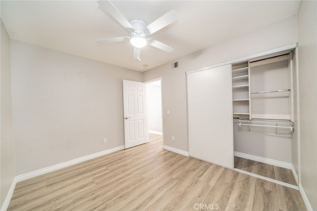 unfurnished bedroom featuring ceiling fan, a closet, and light wood-type flooring