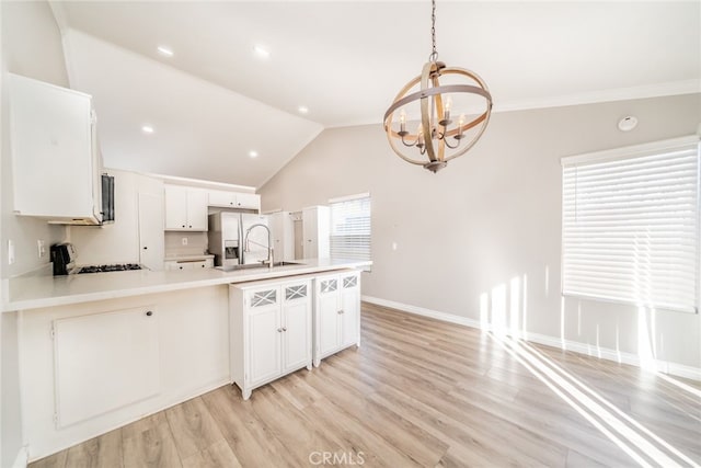 kitchen featuring pendant lighting, white cabinetry, range, and stainless steel refrigerator with ice dispenser