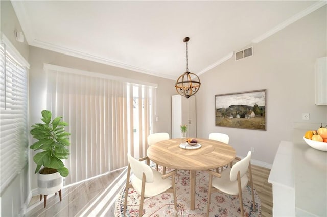 dining space featuring ornamental molding, lofted ceiling, a notable chandelier, and light hardwood / wood-style flooring