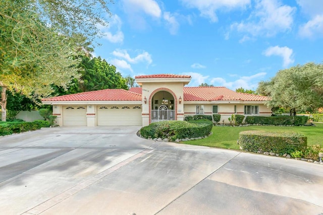 mediterranean / spanish home with a garage and a front yard