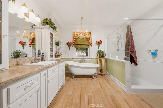 bathroom featuring plus walk in shower, hardwood / wood-style floors, a notable chandelier, and vanity