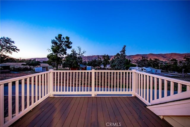 deck at dusk featuring a mountain view