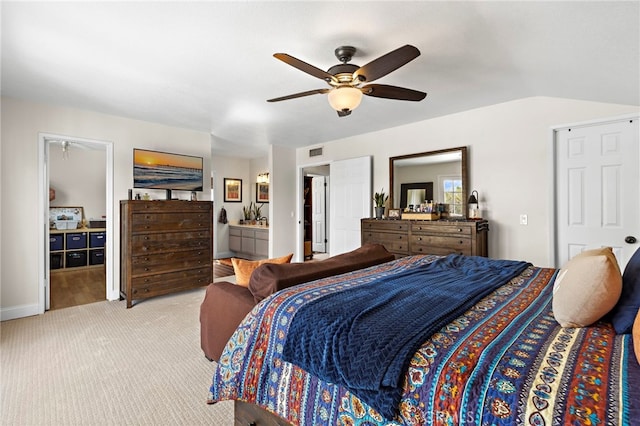 bedroom with visible vents, light colored carpet, lofted ceiling, ceiling fan, and ensuite bathroom