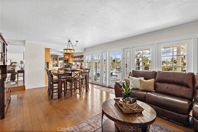 living area with light wood-style flooring, a textured ceiling, and french doors