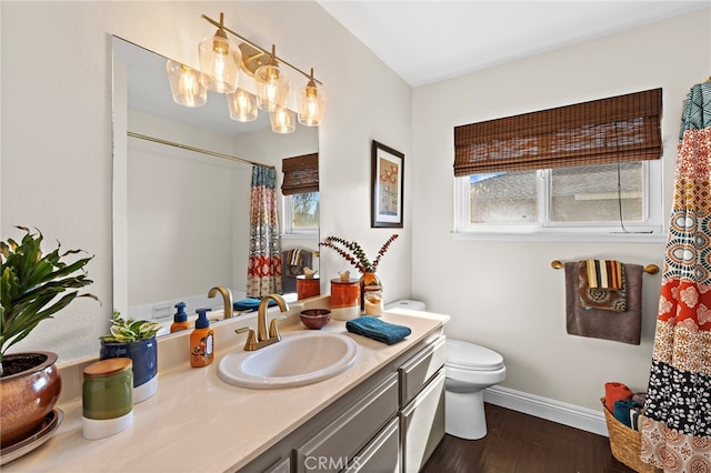 full bathroom featuring a healthy amount of sunlight, toilet, wood finished floors, and vanity