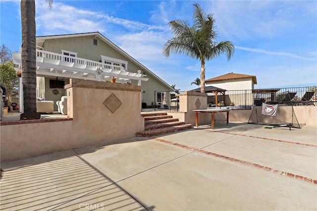 exterior space featuring a patio, fence, a gazebo, a pergola, and stucco siding