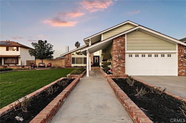 view of front facade with an attached garage, driveway, brick siding, and a front yard