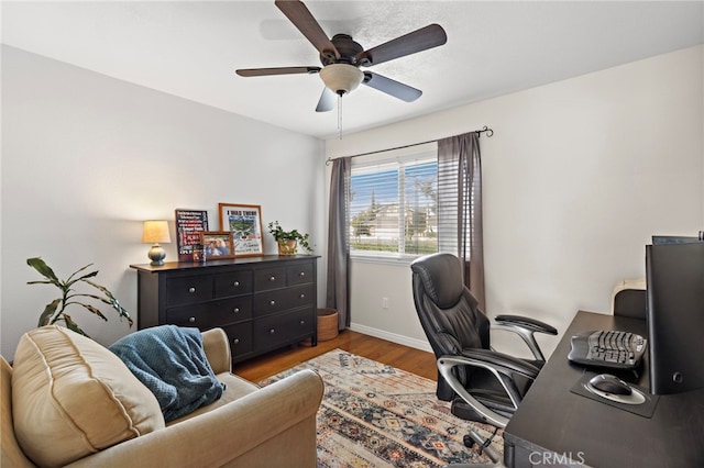 office space featuring ceiling fan, baseboards, and wood finished floors