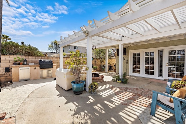 view of patio featuring area for grilling, an outdoor kitchen, fence, and a pergola