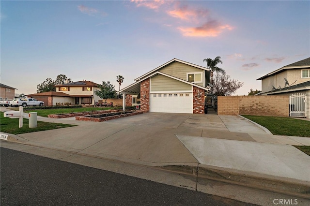 view of front of property featuring a garage, fence, concrete driveway, and brick siding