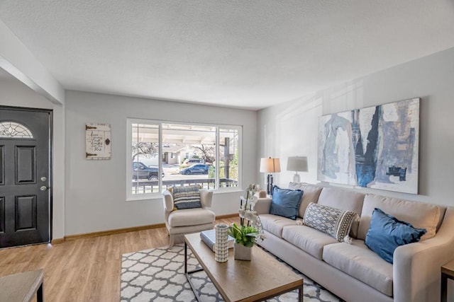 living room featuring light hardwood / wood-style flooring and a textured ceiling