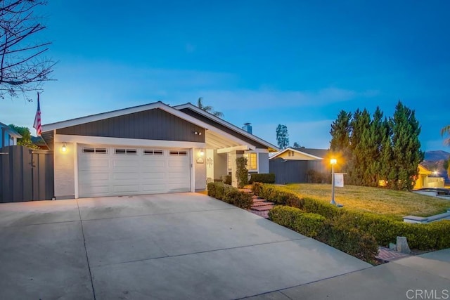 single story home featuring a garage and a yard