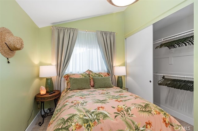 bedroom with lofted ceiling and a closet