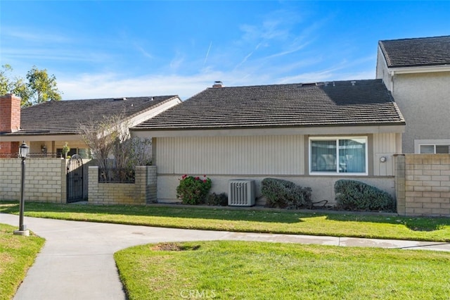 view of property exterior featuring central AC unit and a yard