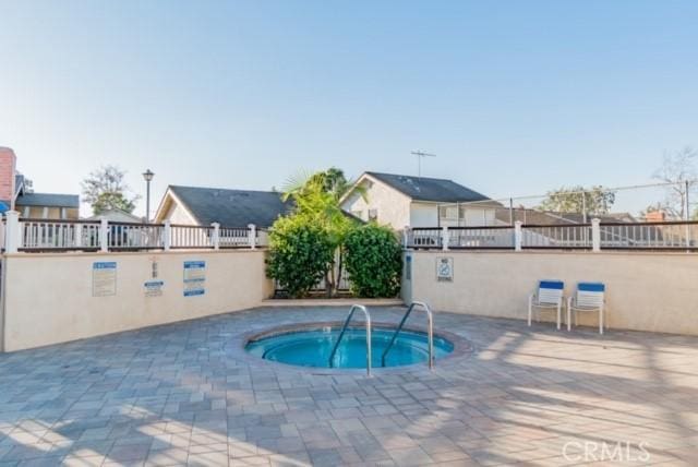 view of pool featuring a community hot tub and a patio area