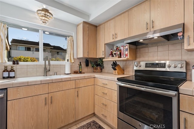 kitchen with light brown cabinetry, backsplash, tile countertops, and stainless steel appliances