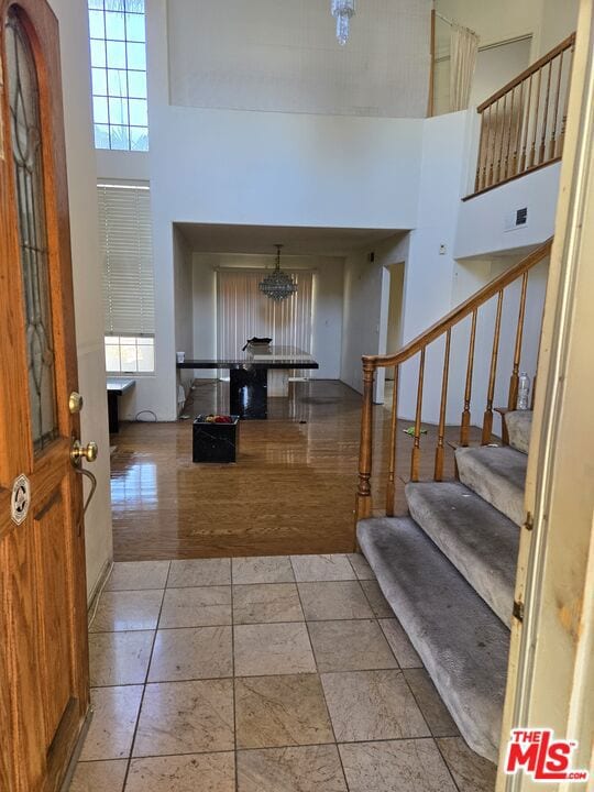 entrance foyer featuring light tile patterned flooring and a towering ceiling