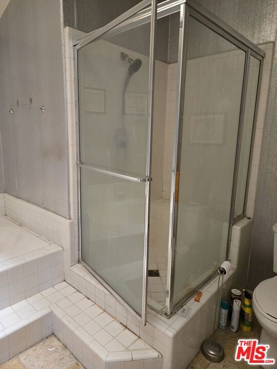 bathroom with an enclosed shower and toilet