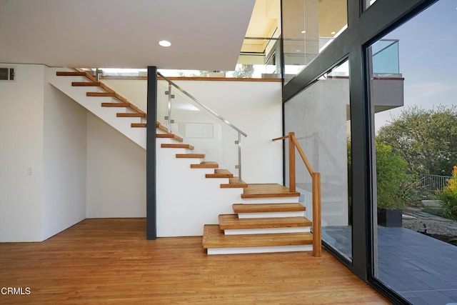 stairs featuring hardwood / wood-style floors