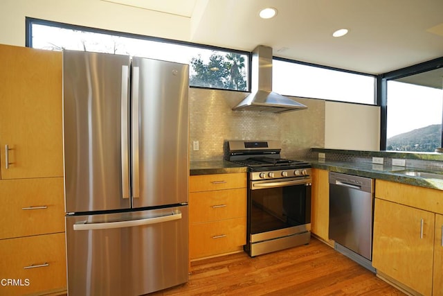 kitchen featuring appliances with stainless steel finishes, sink, backsplash, island exhaust hood, and light wood-type flooring