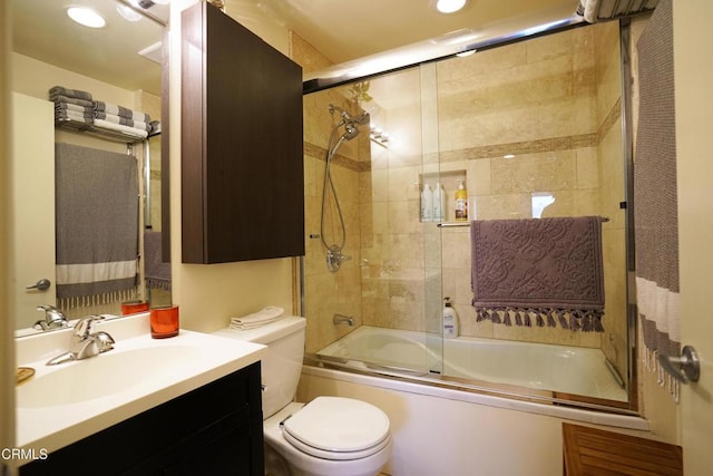 full bathroom featuring bath / shower combo with glass door, vanity, and toilet