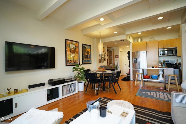 living room featuring beam ceiling and light hardwood / wood-style flooring