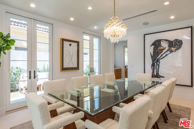 tiled dining space with a notable chandelier and french doors