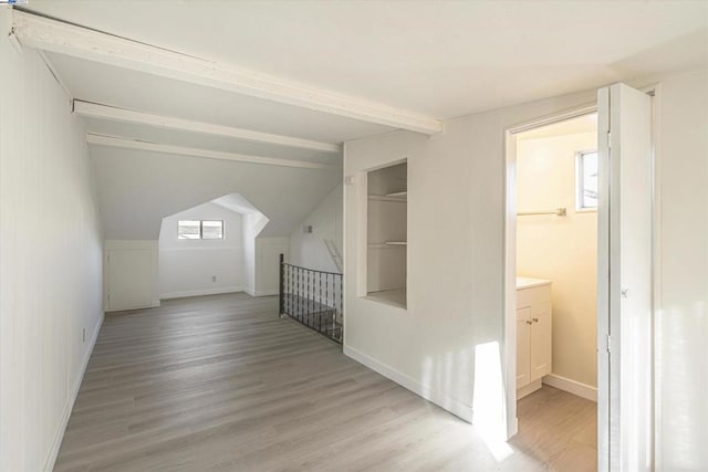 additional living space featuring vaulted ceiling and light hardwood / wood-style floors