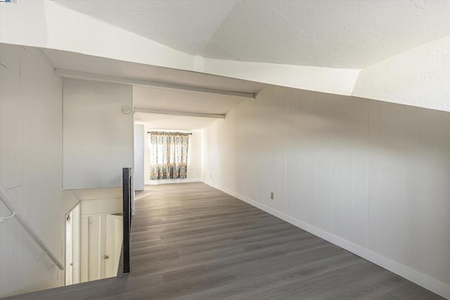 hall with dark hardwood / wood-style flooring and vaulted ceiling