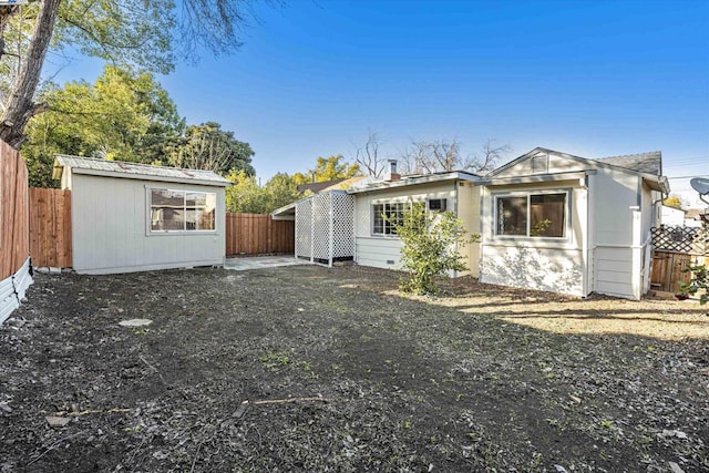 rear view of property featuring an outdoor structure