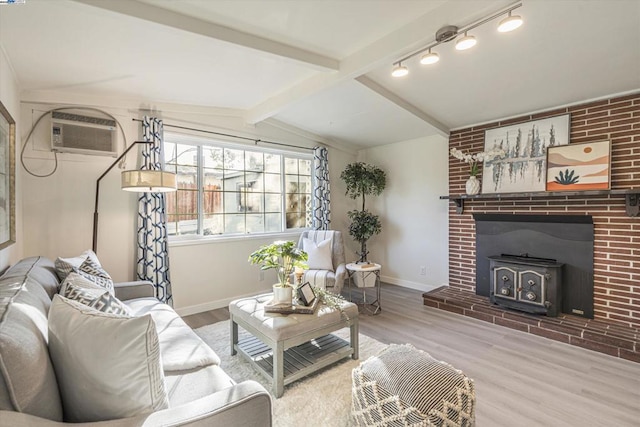 living room with hardwood / wood-style flooring, vaulted ceiling with beams, a wall mounted AC, and a wood stove