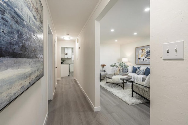 corridor with hardwood / wood-style flooring and ornamental molding