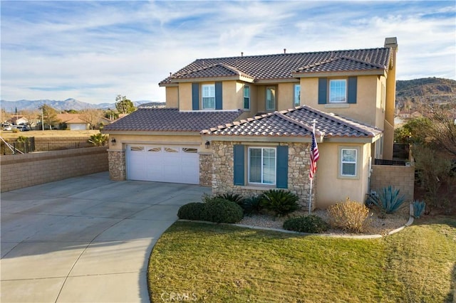 mediterranean / spanish home with a mountain view, a garage, and a front yard