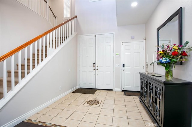 foyer featuring a towering ceiling and light tile patterned floors