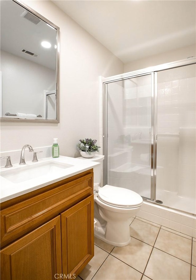 bathroom featuring tile patterned flooring, vanity, a shower with door, and toilet