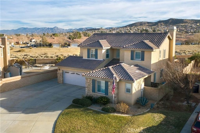 view of front facade featuring a mountain view, a garage, and a front lawn